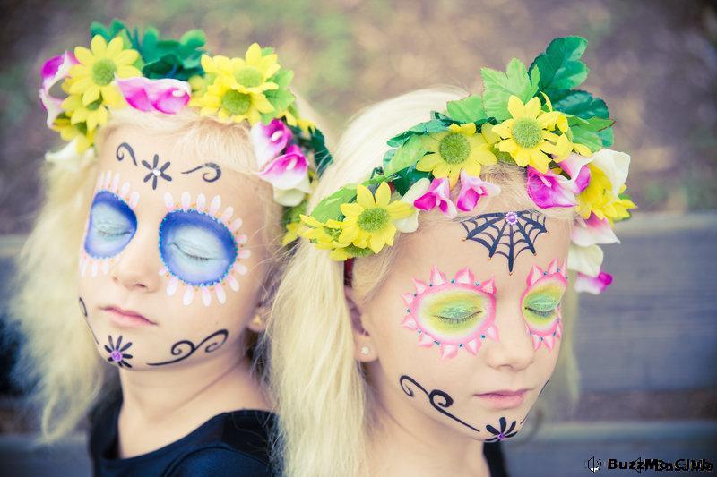 Twin girls with closed eyes in halloween costume outdoors